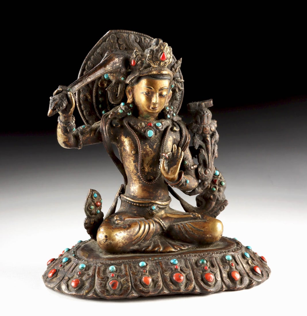 19th C. Tibetan Brass Seated Manjushri w/ Stones: Central Asia, Tibet, ca. 19th century CE. A richly adorned Tibetan brass sculpture of Manjushri, the bodhisattva of wisdom, seated in dhyanasana upon a double-lotus base. The figure is lavishly inlaid