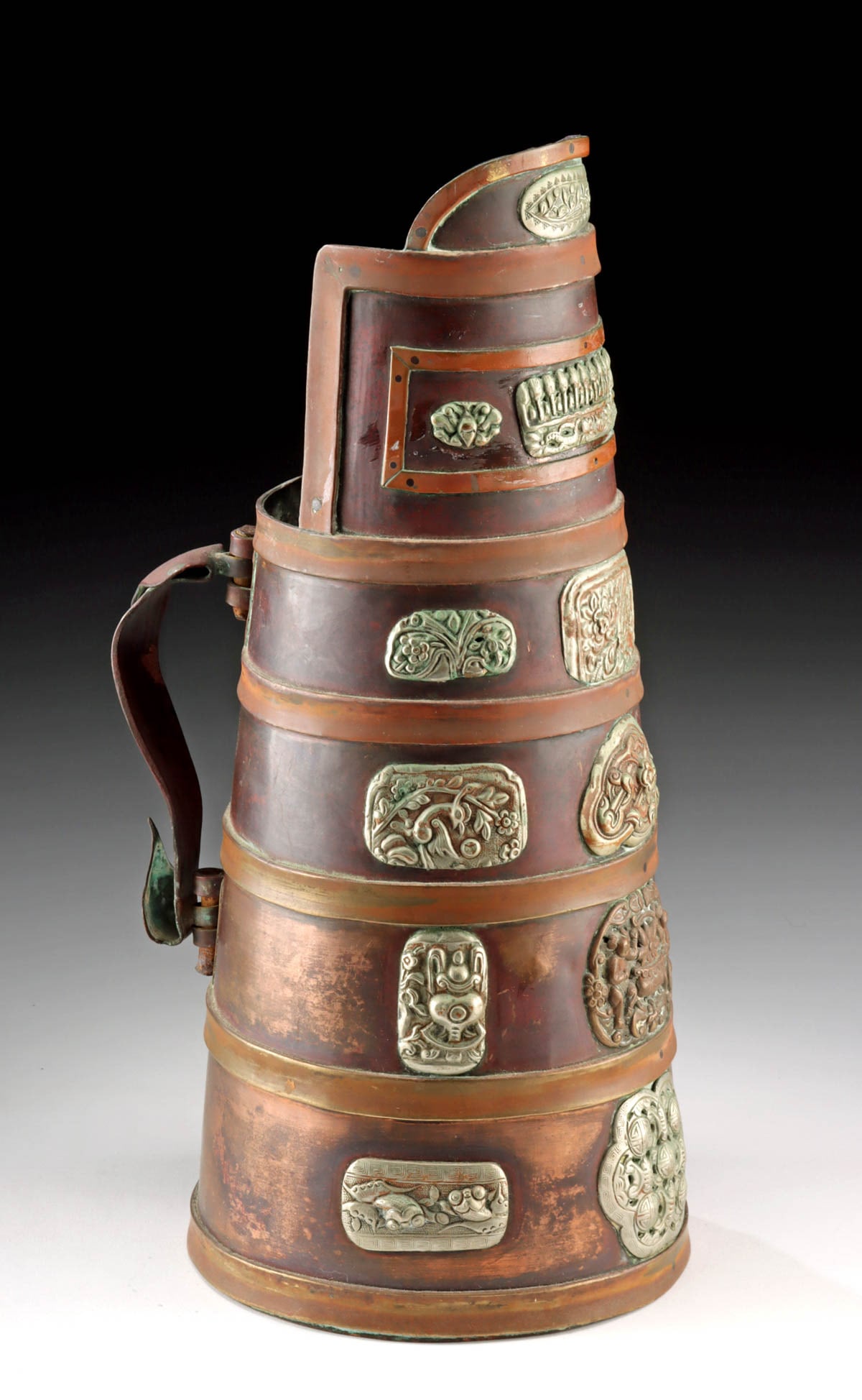 Mongolian Dombo Milk Tea Jug Buddhist Symbol Appliqu: East Asia, Mongolia, ca. early to mid-20th century CE. A copper serving jug, known as a dombo, traditionally used for tea service. The vessel presents a tall, tapered cylindrical form with a broad spo