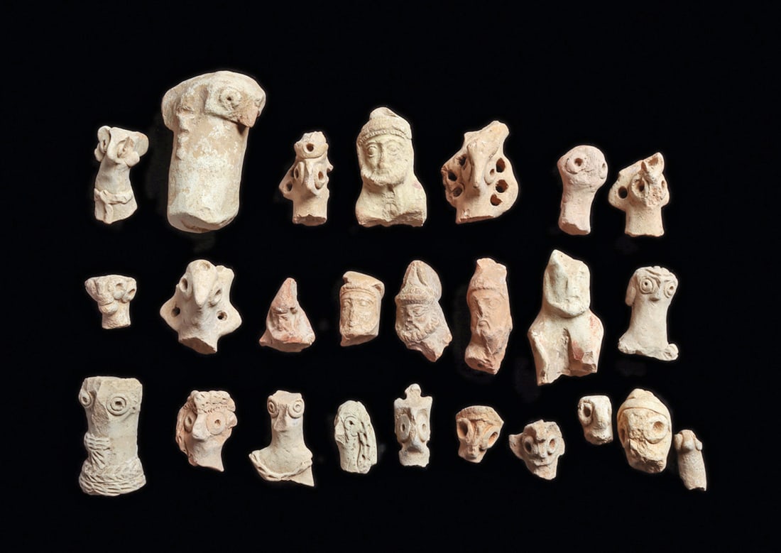 Syro-Hittite Terracotta Heads (25): Group of twenty-five natural pinkish-buff color solid pottery heads, originally from figures, including nineteen of the Syro-Hittite stylized "bird" head types, with large round eyes and beak type nos