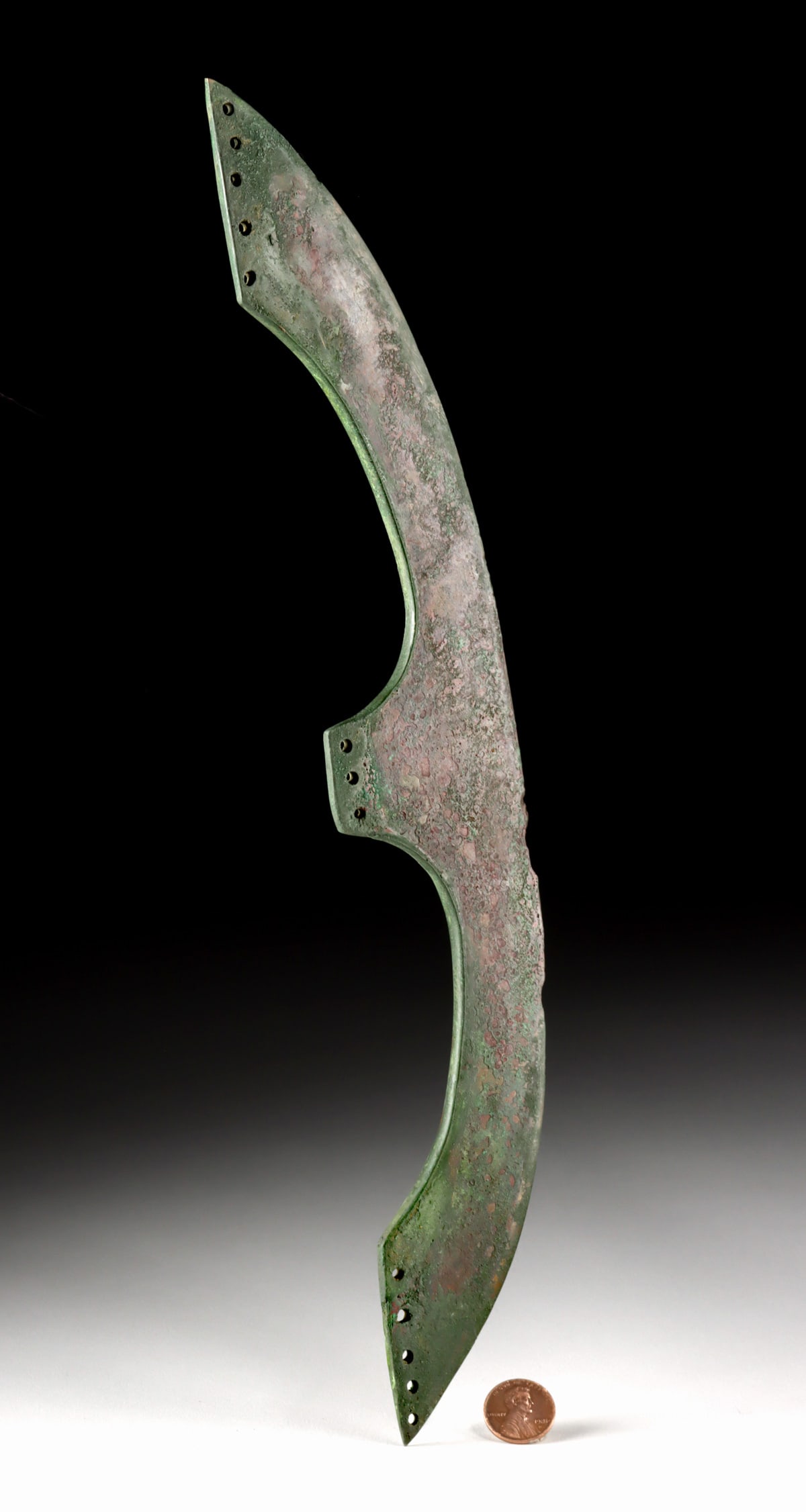 Egyptian Middle Kingdom Bronze Epsilon Axe Blade: Ancient Egypt, Middle Kingdom, ca. 1981 to 1802 BCE. This bronze axe blade is formed in a dramatic crescent profile, an effective design that extends the cutting edge for use in combat and