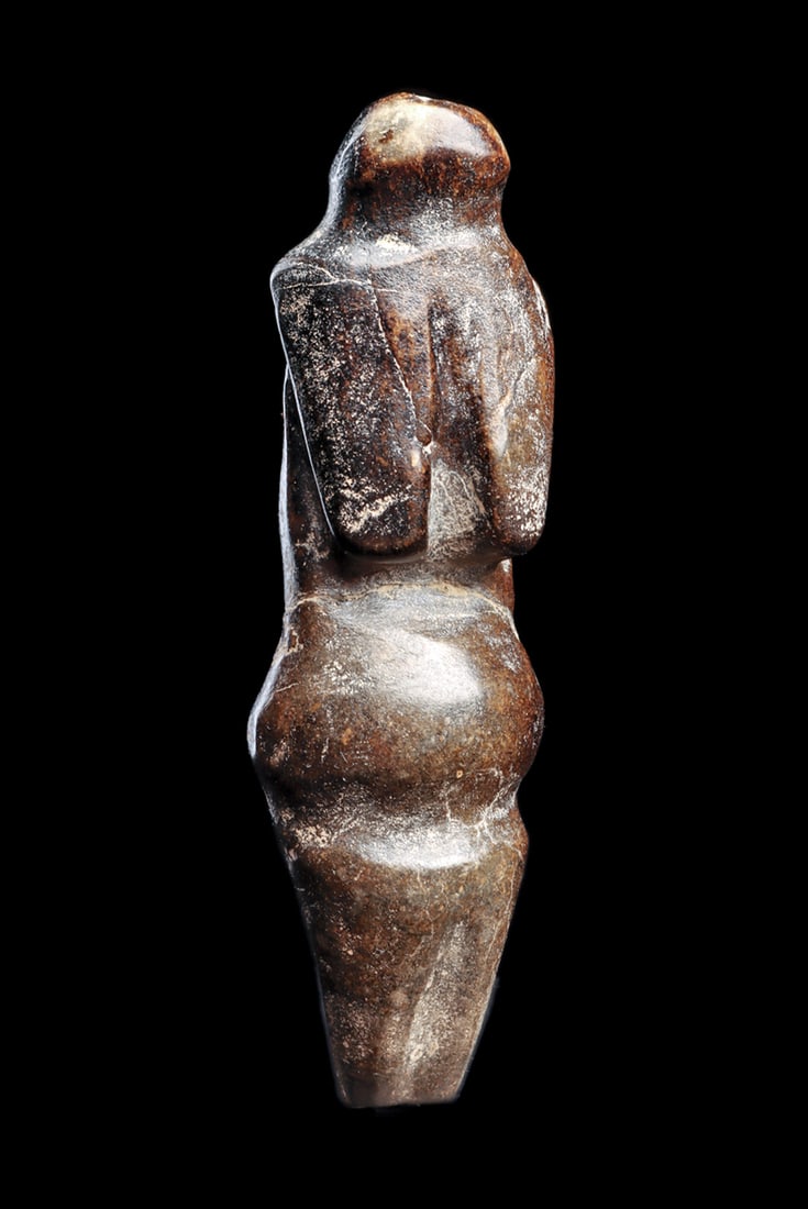 Neolithic Black Stone Venus Figure: Carved black stone female Venus fertility idol, depicted with large elongated breasts, full rounded stomach and tapered legs. Reverse with a rectangular form curved back and legs. Repaired clean break