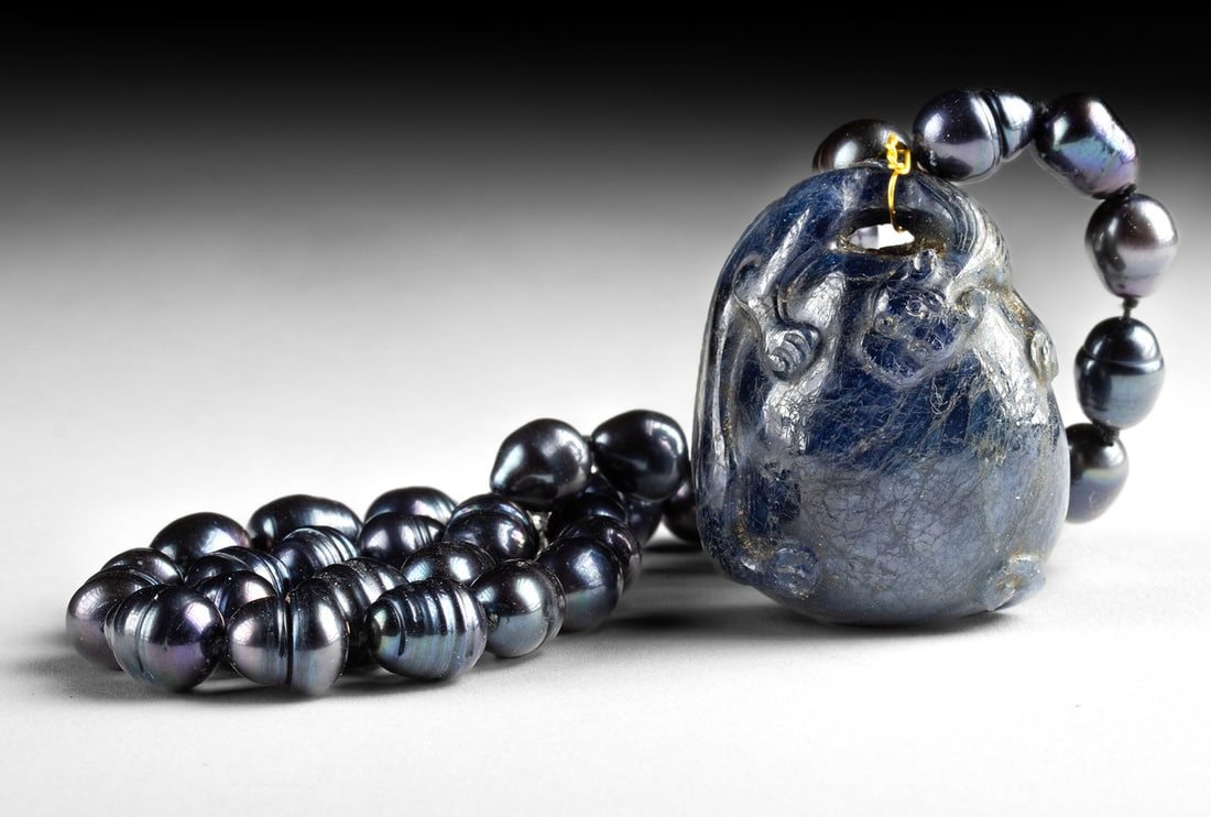 Exhibited Qing Star Sapphire Feline Pendant 300 Carats: Asia, China, Qing Dynasty, ca. 18th century CE. Expertly carved from a single piece of deep blue sapphire, weighing a huge 300 carats, exhibiting a soft asterism (star), the figure depicts a seated fe