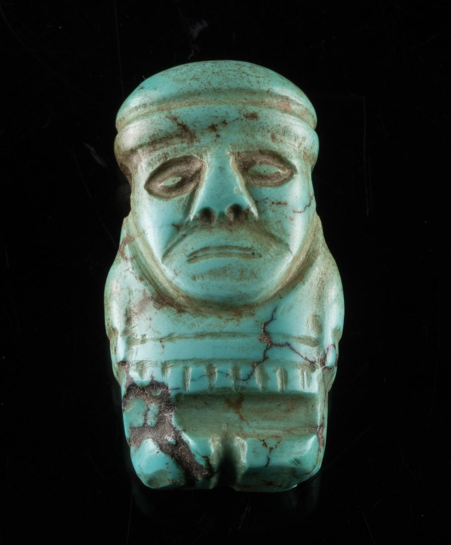 Rare Turquoise Pre-Columbian Wari Warrior Pendant: Pre-Columbian, Peru, Huari (Wari) culture, ca. 600 to 1000 CE. A rare turquoise figural pendant carved in the form of a standing male warrior or lord. The figure is characterized by a disproportionate