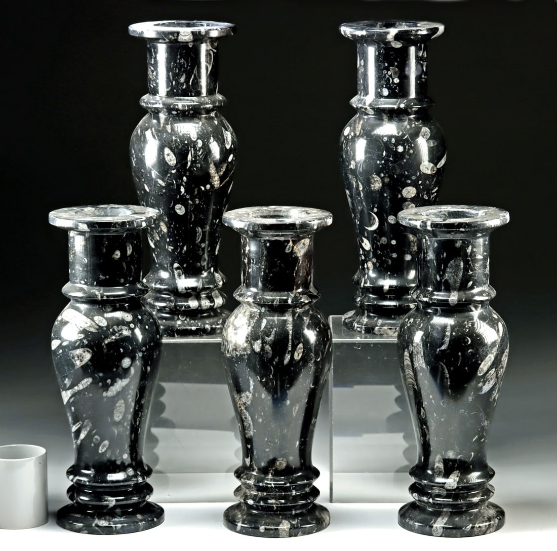 Five Carved Ammonite Shell Fossil Matrix Marble Vases: North Africa, Morocco, Devonian Period, ca. 419.2 to 358.9 million years ago. A group of five urn-like vases carved from deep black stone naturally speckled with white quartzite fossils, including vis