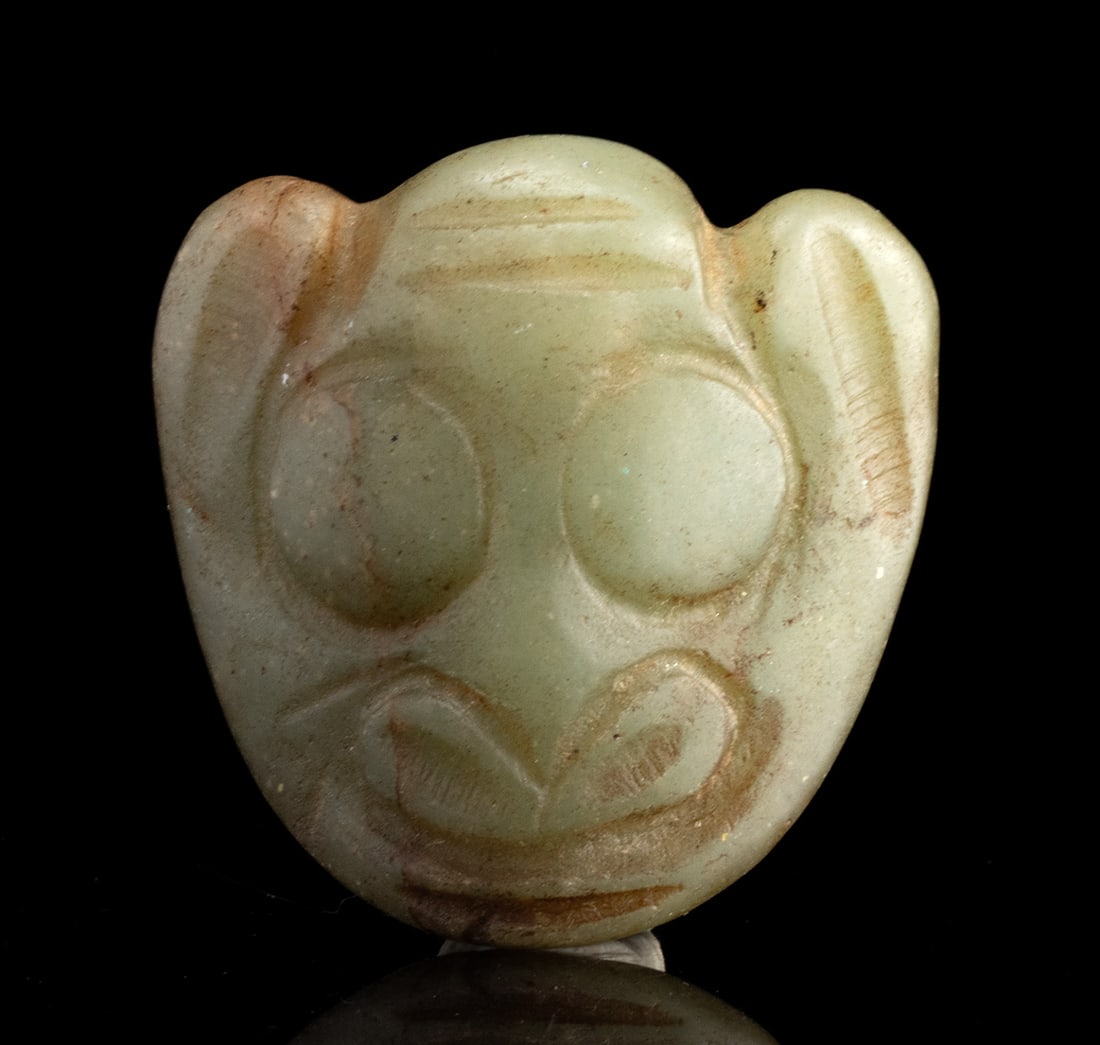 Neolithic Hongshan Jade Zoomorphic Face Pendant: East Asia, China, Neolithic period, Hongshan culture, ca. 4700 to 2900 BCE. A refined jade pendant carved as a stylized zoomorphic face, attributed to the Neolithic Hongshan culture of northeastern Ch