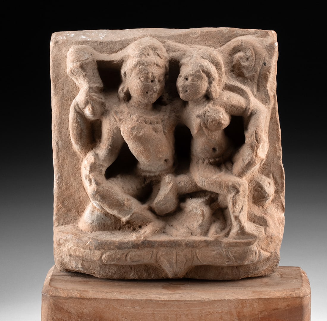 10th C. Indian Sandstone Shiva & Parvati Uma Maheshvara: South Asia, Indica, ca. 9th to 10th century CE. A sandstone high-relief panel depicting Shiva and Parvati in the intimate devotional scene known as Uma-Maheshvara. The divine couple sits closely toget