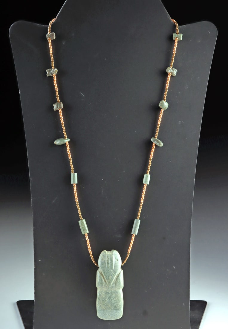 Costa Rican Stone Avian Celt Beaded Necklace: Pre-Columbian, Central America, Costa Rica, ca. 800 to 1200 CE. An elegant necklace centered on a Costa Rican greenstone avian pendant, its softly abstracted form capturing the grace and symbolism of