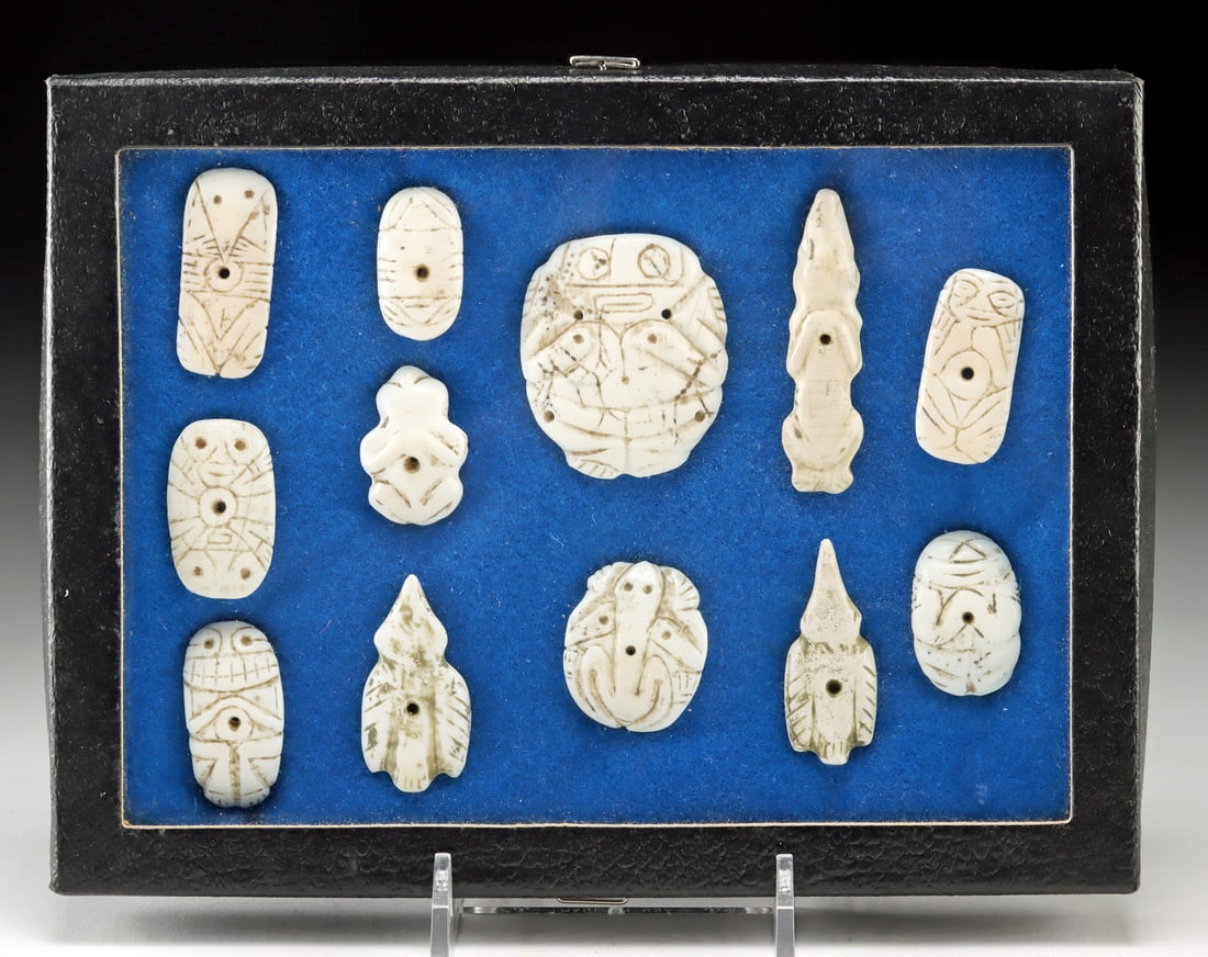 Taino Collection of 12 Shell Zemi & Animal Pendants: Pre-Columbian, Caribbean, perhaps Dominican Republic, Taino (Arawak) peoples, ca. 1000 to 1500 CE. A group of 12 shell zemi and zoomorphic pendants consisting of small pierced plaques and figural