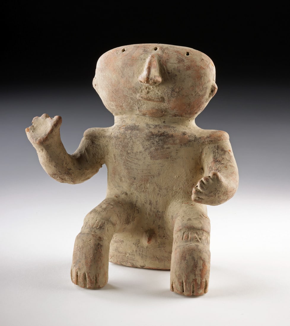 Quimbaya Pottery Seated Nude Male Figure: Pre-Columbian, Colombia, Quimbaya culture, ca. 700 to 1600 CE. A compelling example of Quimbaya figural pottery, this seated nude male figure presents a direct and highly individualized form marked