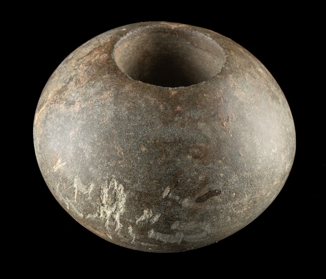 Ancient Andean Spherical Stone Mace Head Weapon: Pre-Columbian, Peru, Moche to Inca Empire, ca. 100 to 1500 CE. A stone mace head carved in a rounded, globular form with a central perforation for hafting. Size: 3.2" L x 2.3" W (8.1 cm x 5.8 cm) Pro