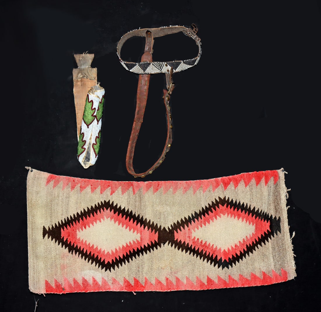 Navajo Textile, Horse Bridle & Beaded Doll Cradleboard: Native American, United States, Nez Perce & Navajo (Dine), ca. late 19th to 20th century CE. A collection of Native American beadwork, textile, and equestrian elements. The group features a beaded lea