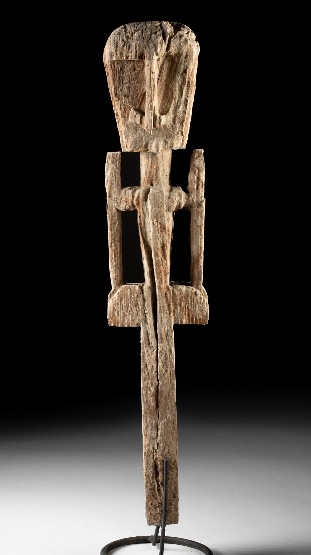 Western New Guinea Wood Ancestral Figure Carving: Southeast Asia, Indonesia, Western New Guinea, ca. 19th to early 20th century CE. A carved wooden ancestral figural post, featuring an oversized head with angular facial planes, openwork arms, and a w