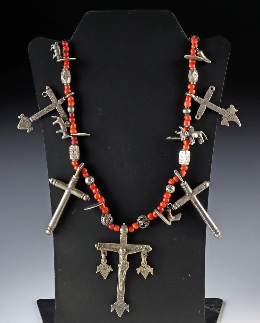 Guatemalan Glass Bead & Silver Cross Chachal Necklace: Latin America, Guatemala, ca. early to mid-20th century CE. A Chachal necklace composed of red glass beads interspersed with silver elements including milagros, crucifix pendants, open filigree wire s