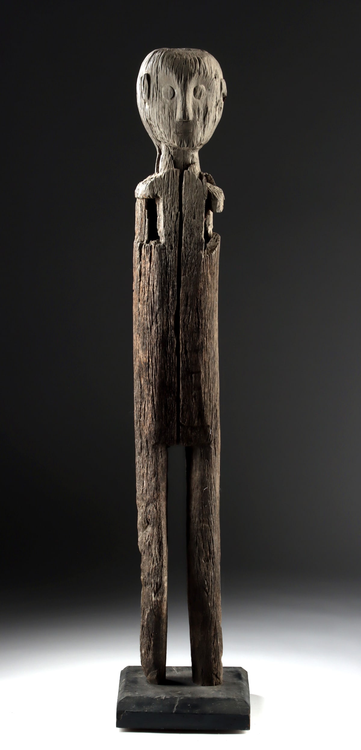 Large Indonesian Wood Ancestor Figure: Oceania, Indonesia, Borneo, Dayak Kayan / Kenyah, ca. 19th to early 20th century CE. A tall wooden hampatong ancestor-guardian figure with elongated proportions and a calm, watchful face, its surface