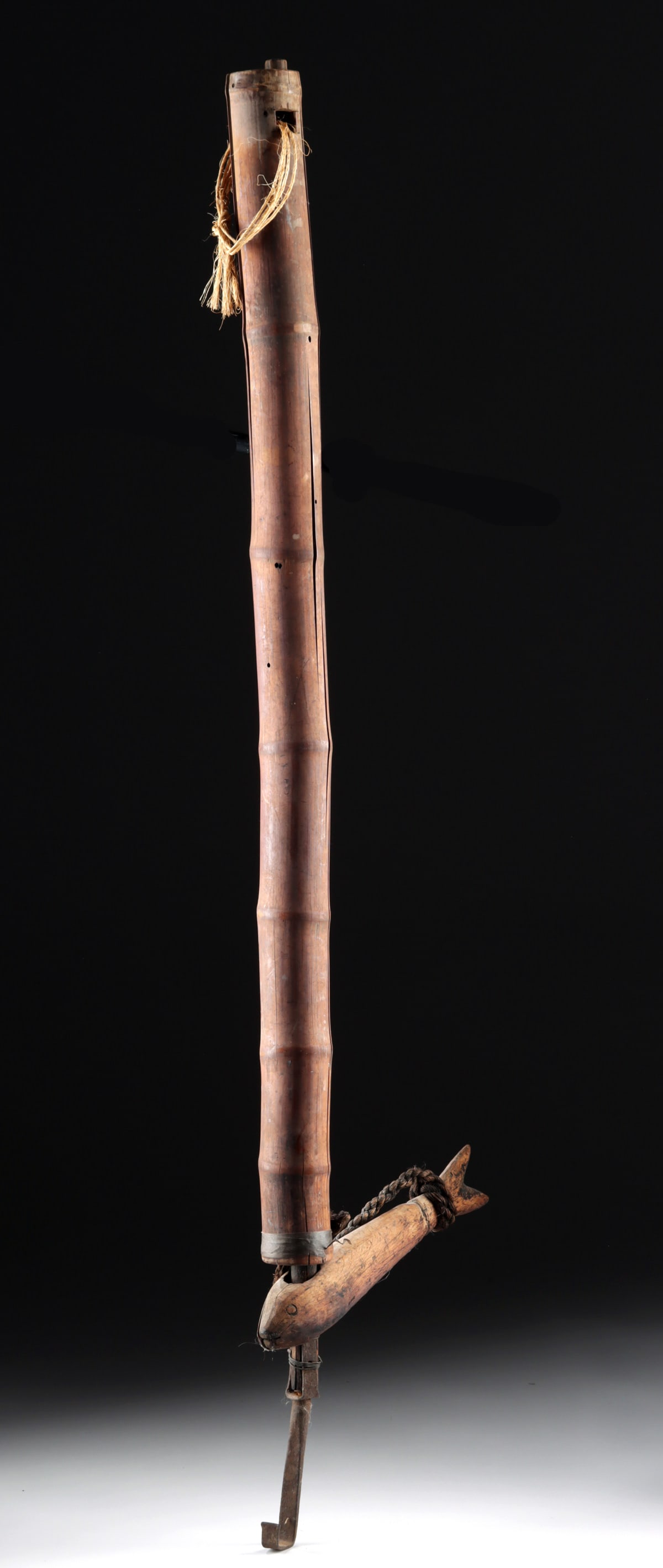 1930s Japanese Jizai Kagi Hearth Hook w/ Fish Ornament: East Asia, Japan, ca. 1930s to 1940s CE. A wooden hearth hook - called a jizai kagi - with an iron hook attached to the end of a wooden rod. The rod is housed within a bamboo case with a thick rope ti