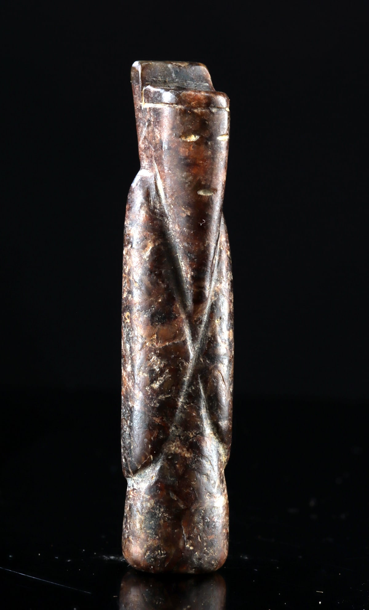 Ancient Style Chinese Carved Stone Figure Amulet: East Asia, China, ca. 20th century CE. A small stone carving depicting a simplified civil servant or attendant figure with folded arms and a long robe indicated by gently incised diagonal folds. The h