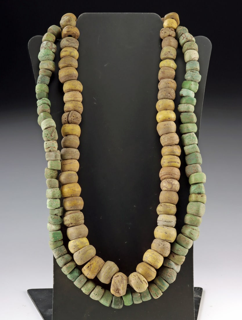 Israeli Hebron Glass Bead Strands in Yellow & Green: Near East, Israel, Hebron, ca. 19th century CE. A pair of necklaces composed of Hebron glass trade beads. The beads were produced from salt glass using winding or molding techniques and display the ch