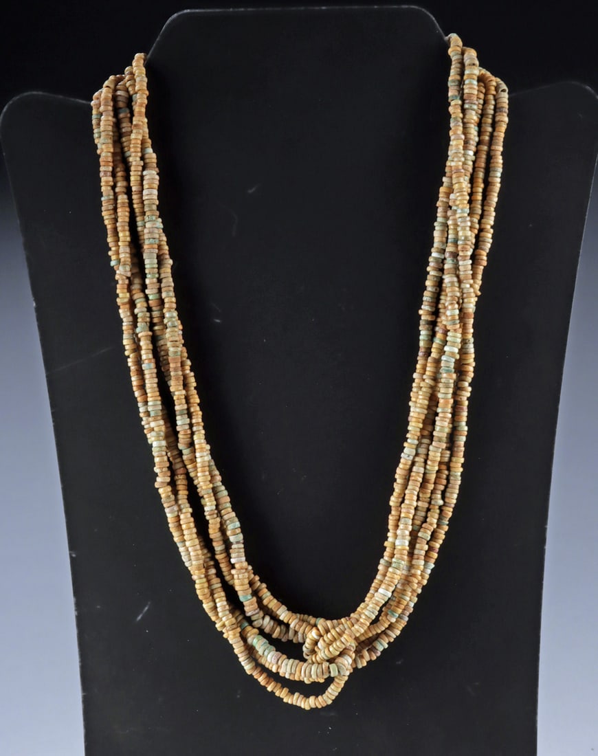 Ancient Egyptian Faience Bead Multi Strand Necklace: Egypt, New Kingdom to Late Period, ca. 1550 to 332 BCE. A multi-strand necklace composed of numerous ancient faience disk beads in warm tan hues with scattered pale turquoise tones. The strands are