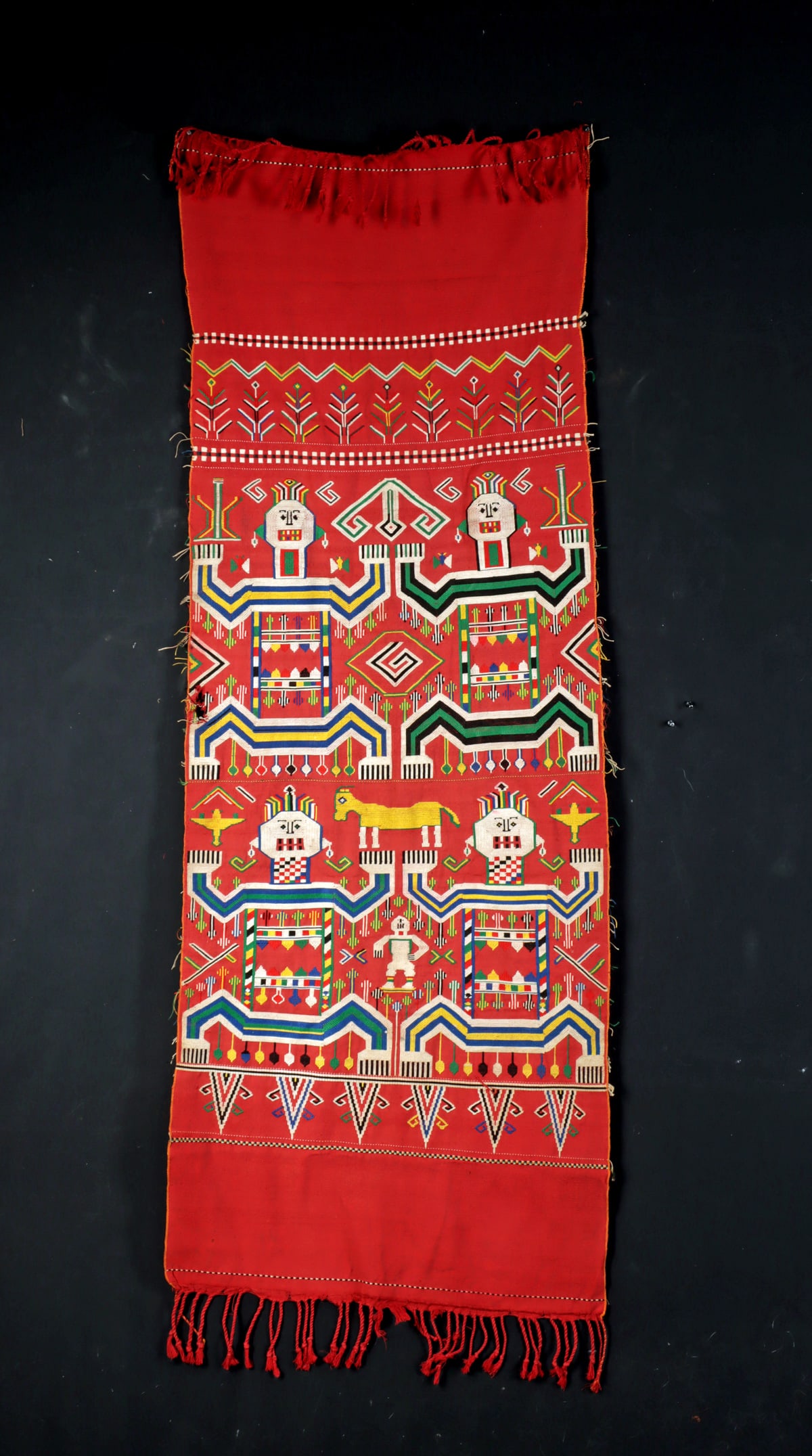 Vibrant Borneo Iban Woven / Embroidered Textile: Southeast Asia, Indonesia, Borneo, Iban culture, ca. mid to late 20th century CE. A textile with a red ground decorated with colorful supplementary weft and embroidered designs depicting stylized huma