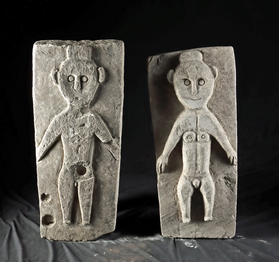 Two Sumatra Stone Figural Plaques - Nude Male & Female: Southeast Asia, Indonesia, Sumatra, ca. 20th century CE. A striking pair of carved stone figural relief panels depicting stylized nude human figures in frontal view, one male and one female, each wear