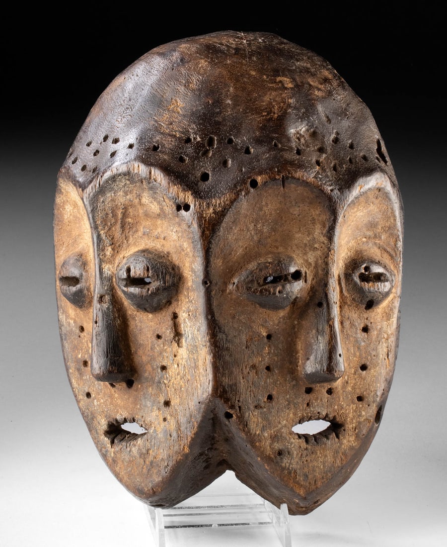DR Congo Lega Janiform Face Mask for Bwami Society: Central Africa, Democratic Republic of the Congo, Lega culture, ca. 19th to early 20th century CE. A carved wooden double-face mask with remains of white kaolin pigment, presenting janiform heads join