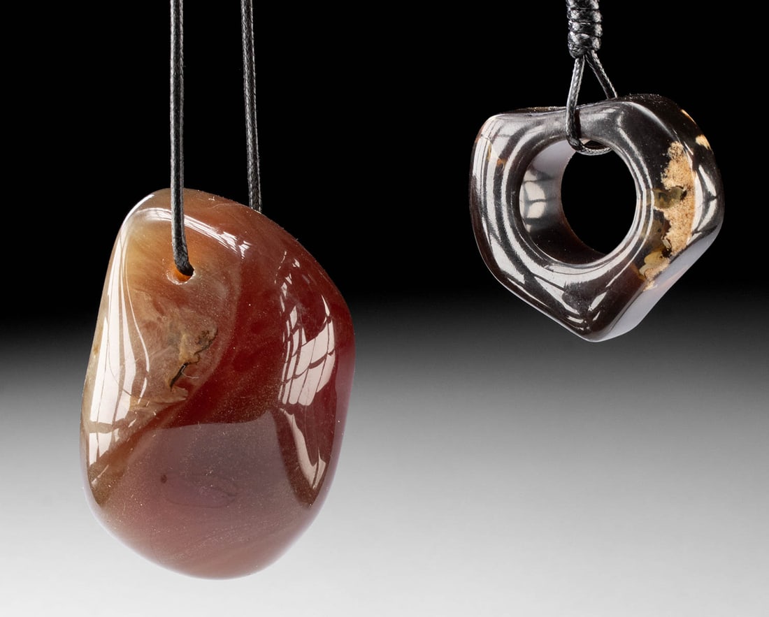 Pair of Large Sumatran Amber Pendants: Southeast Asia, Indonesia, Sumatra, ca. late 20th to early 21st century CE. A striking pair of Sumatran amber pendants, each carved and polished to emphasize the natural depth and warmth of the materi