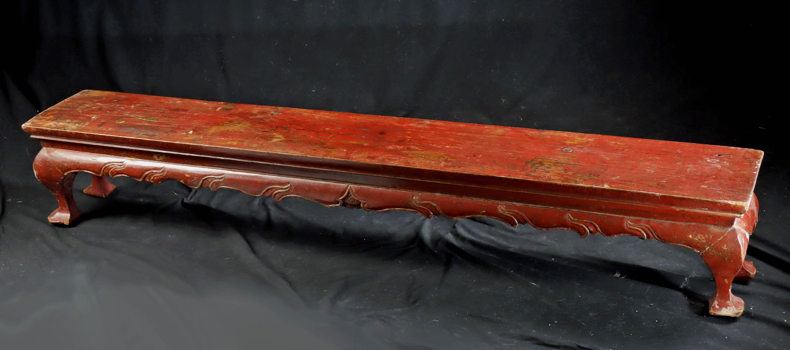 Chinese Qing Dynasty Cinnabar Kang Bench / Table: East Asia, China, Qing Dynasty, ca. 19th to early 20th century CE. A long, low wooden kang bench or side table constructed with tenon-jointed legs and a rectangular plank top, a form traditionally use