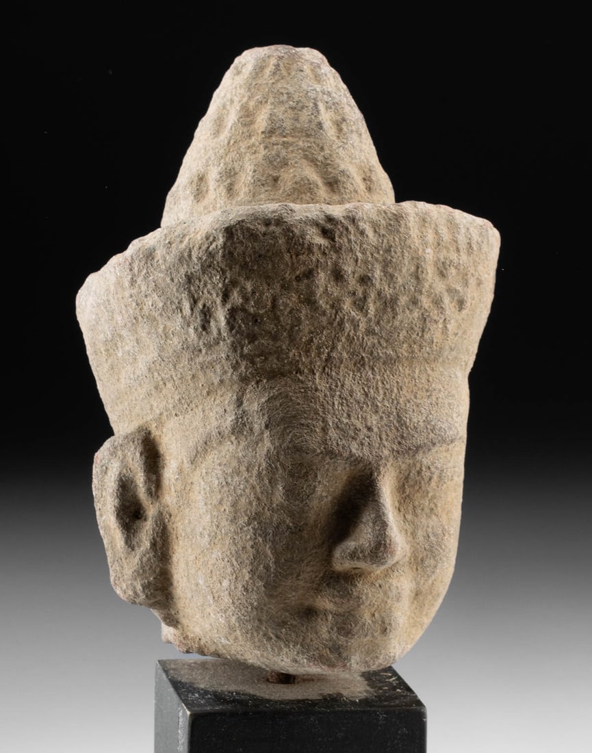 12th C. Khmer Sandstone Head of a Male Deity: Southeast Asia, Cambodia, Khmer Empire, Angkor Wat period, ca. 12th century CE. A serene sandstone head of a male deity, carved in the refined Angkor Wat style of the 12th century, embodies the spirit