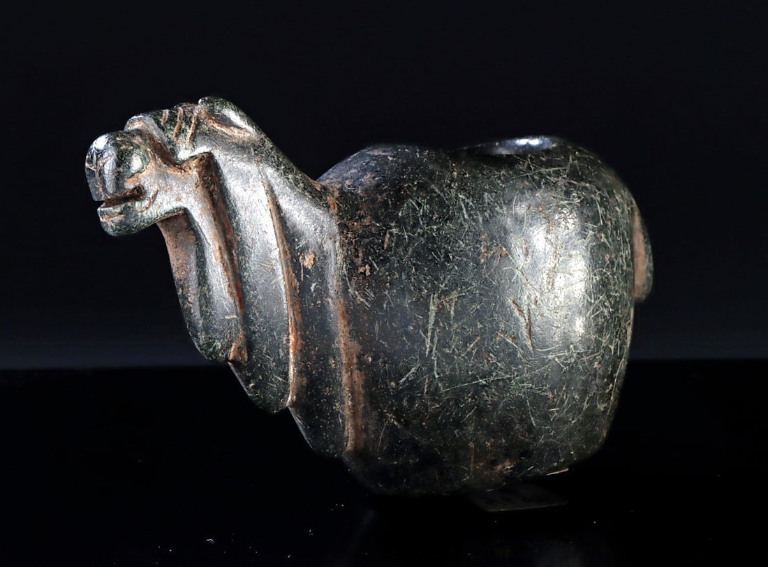 Inca Stone Llama Canopa Offering Vessel: South America, Peru / Bolivia, 15th to 16th century CE. A hand-carved stone canopa offering vessel in the form of a llama with a circular offering receptacle atop its back. Small stone figures like th