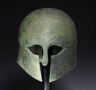 Greek Corinthian Bronze Helmet, ex-Artemis Gallery: Greece, Corinthian Type, ca. 6th-5th Century BCE. A fine bronze Corinthian helmet formed of one sheet of bronze, with traditional eye openings, nose guard, and subtle short rear flange. A beautiful gr