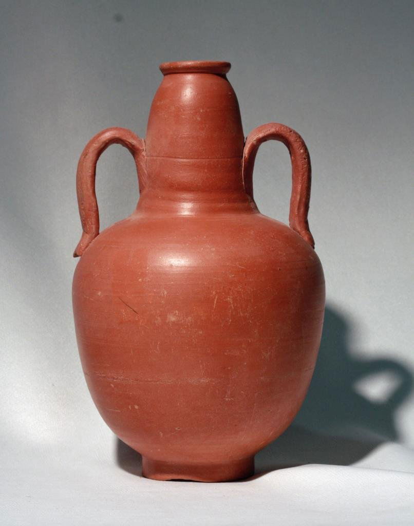 Roman North African Terra Sigillata Jug: Carthage, North Africa, 100-300 CE. Pristine ancient redware pottery vessel with elegant twin handled shape with an intricate trailing floral or wine vine pattern on each handle. The two handles were