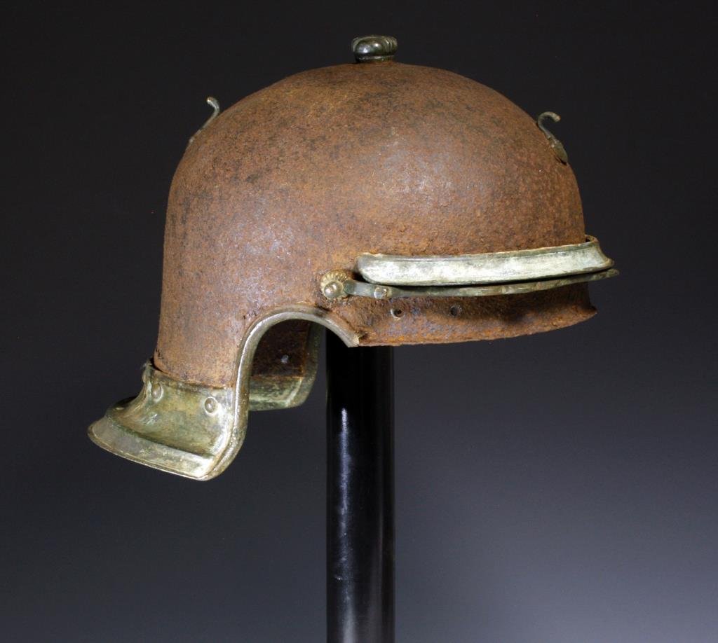 Roman Bronze / Iron Military Helmet: Rome, ca. 200 - 300 CE. With iron bowl and bronze visor and neck flange. Small bronze nob on top of helmet. 11" x 8-1/2". Provenance: Ex-M. Carini Collection, CA; Ex- Galeria Antica, UK; Ex-Old German