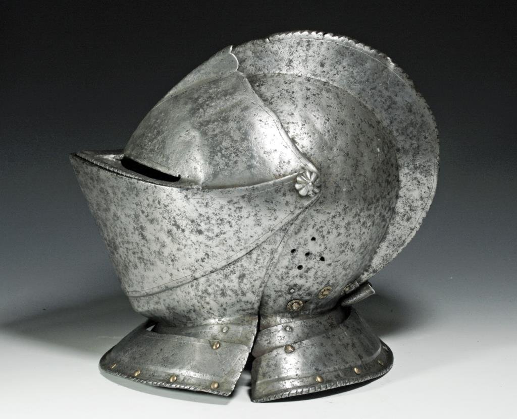 German Knight's Close Helmet, Ex-Hermann Historica: Germany, ca. 10th - 13th Century CE. A steel formed knight's helmet with two retractible visors (eye and mouth), center steel cresit with incised decoration, and neck guard. Breathing holes stamped ar