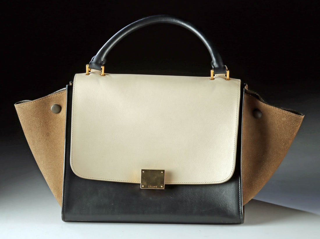 Celine Tricolor Leather Trapeze Bag (2014): Crafted in Italy in 2014, the design pairs smooth black leather with a beige flap and soft tan suede side panels of calf hair, creating a subtle contrast of tone and texture. The structured silhouette