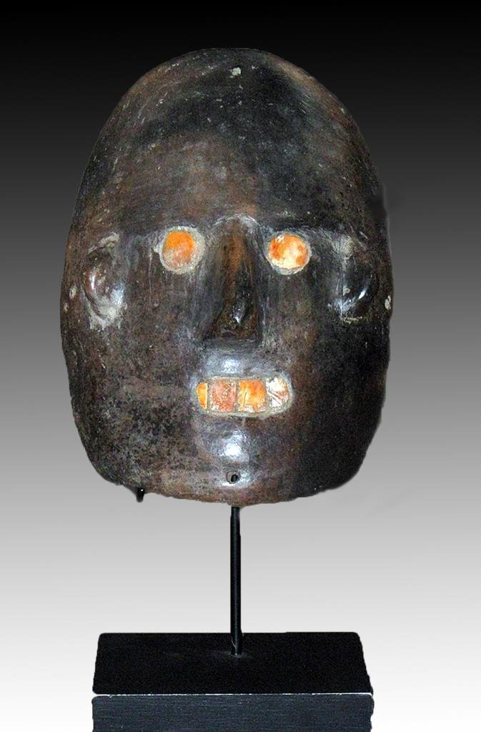 Colima Mask with Spondylus Eyes: Pre-Columbian, ca. 200 BCE to 200 CE. Blackware pottery mask of male face with shell eyes and mouth. Custom stand. 8-1/4" x 6" x 3". Provenance: Ex-Robert Morris Fine Arts, Santa Fe, NM The starting p