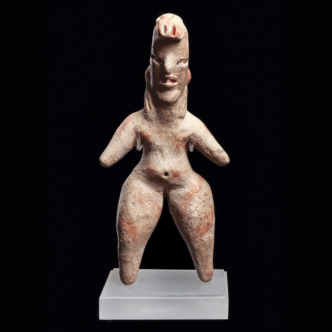 Tlatilco Pottery Standing Female Figure: Tlatilco. Ca. 1150 - 550 BCE. Solid pottery standing female figure, having a cream slip ground with traces of orange-pink painted highlights and striped decoration. Depicted with a large stippled hair