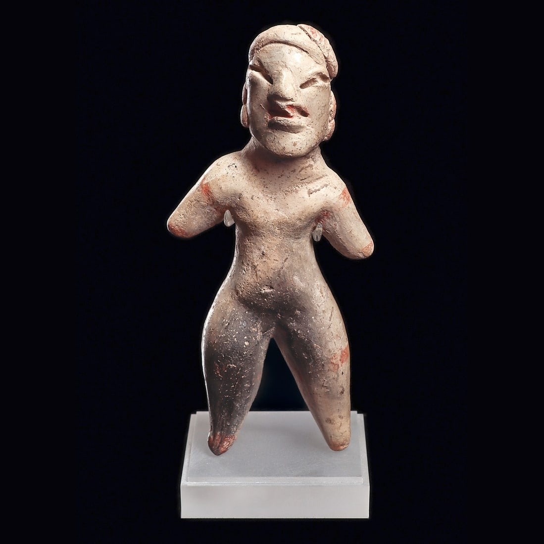Tlatilco / Olmecoid Female Figure: Tlatilco. Ca. 1150 - 550 BCE. Solid pottery standing female figure holding her short arms away from her sides, having splayed legs. Cream slip ground with a few remaining traces of painted red decorat