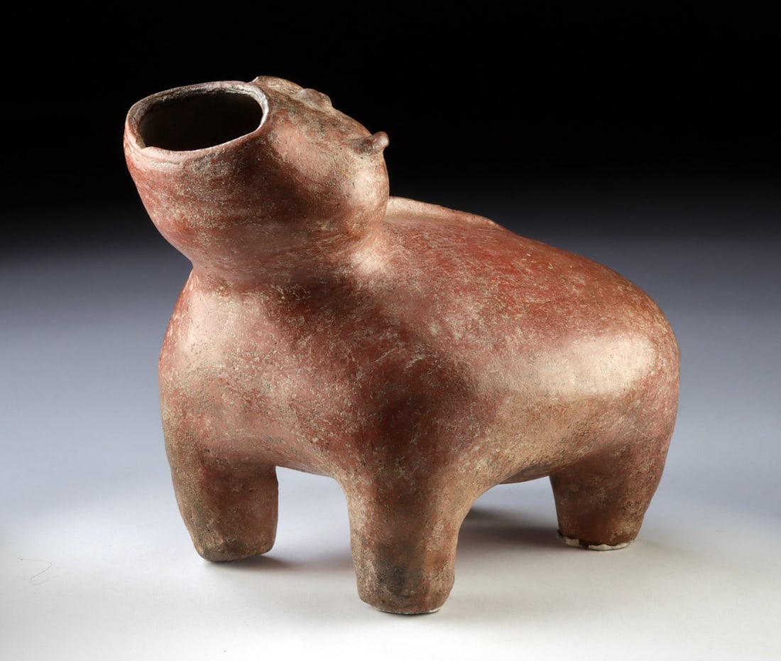 Colima Redware Effigy Howling Dog Vessel: Pre-Columbian, West Mexico, Colima, Protoclassic Period, ca. 100 BCE to 250 CE. An impressively intact effigy vessel hand-built in burnished terracotta and modeled in the form of a howling Xoloitzcuin