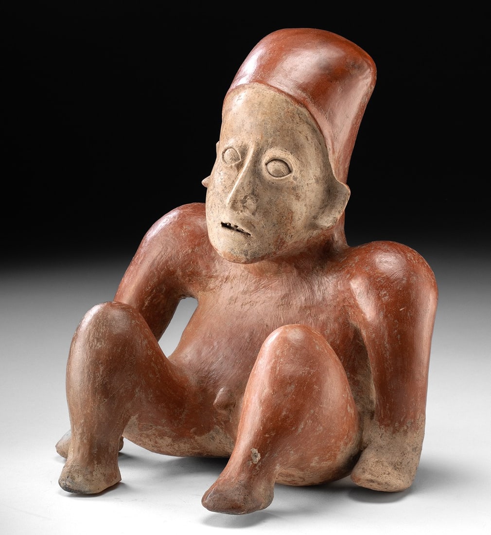 Jalisco Pottery Seated Nude Male Hunchback Figure: Pre-Columbian, West Mexico, Jalisco, ca. 300 BCE to 300 CE. A compelling Jalisco pottery figure depicting a nude male hunchback seated with bent legs and arms braced behind the body. The figure wears 
