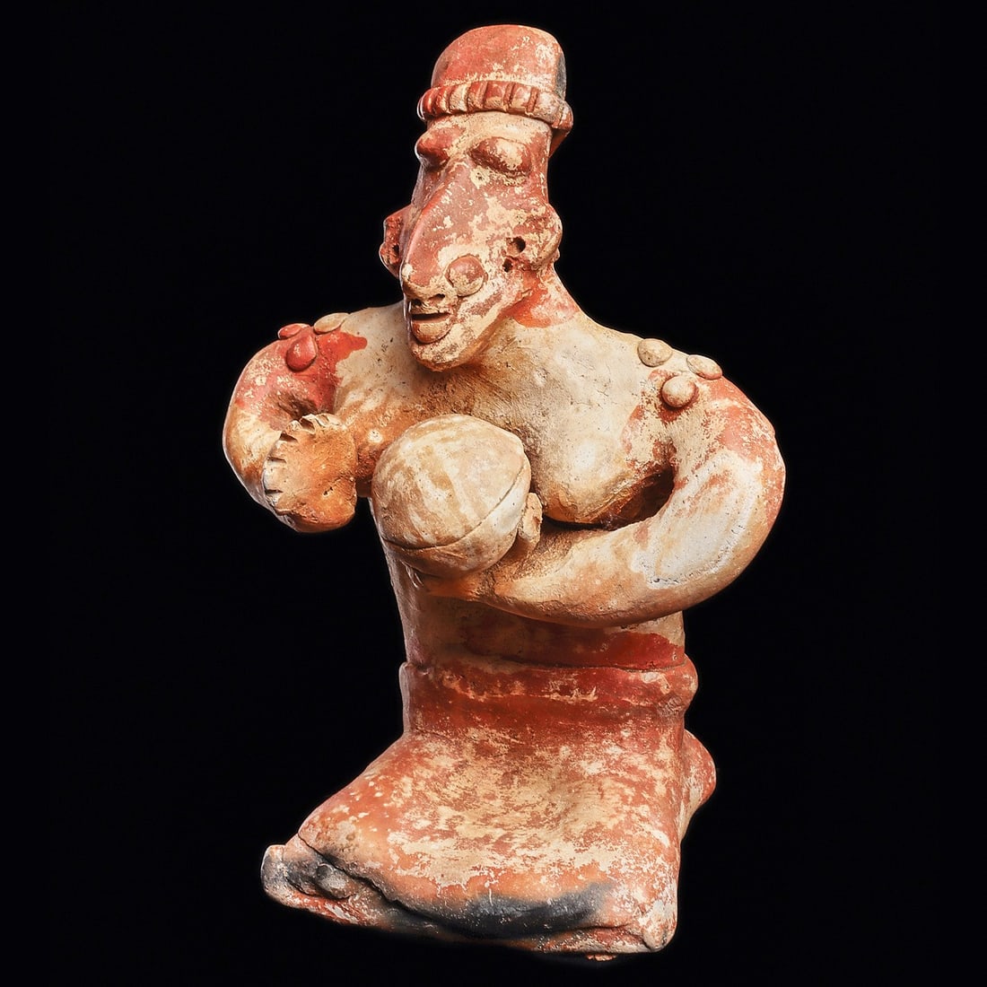 Jalisco Solid Seated Woman Holding Covered Dish: Jalisco. Ca. 100 BCE - 250 CE. Dark orange over cream slip decorated solid pottery seated female figure holding a covered dish in her left hand. Wearing a knee length skirt, segmented headband, pierce