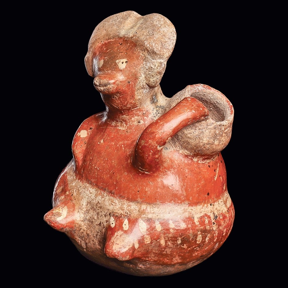 Chinesco Bulbous Sitting Woman Holding Pot, Type E: Nayarit. Ca. 100 BCE - 250 CE. Red-orange painted pottery seated figure, having a bulbous body, holding an olla on her left shoulder. Painted black and white details and decoration. Scattered mineral 