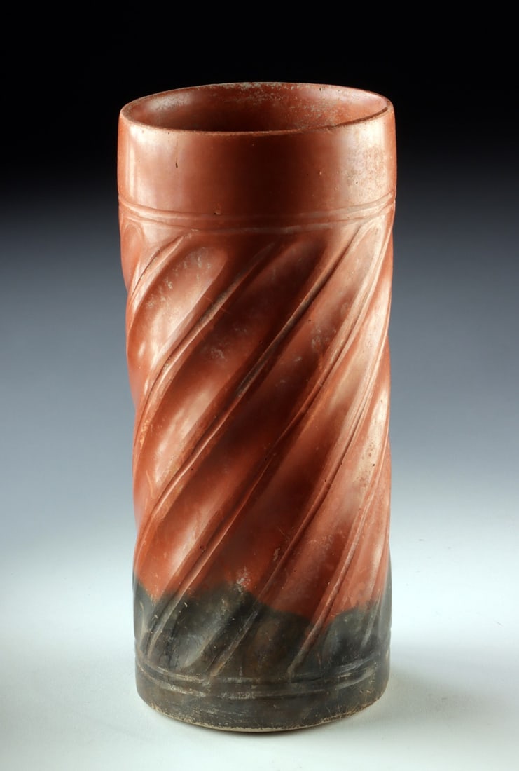Maya Pottery Cylinder Vase with Diagonal Fluting: Pre-Columbian, Mesoamerica, Maya culture, ca. 610 to 900 CE. A finely proportioned Maya pottery cylinder vessel distinguished by bold diagonal fluting that spirals gracefully around the body. The vess