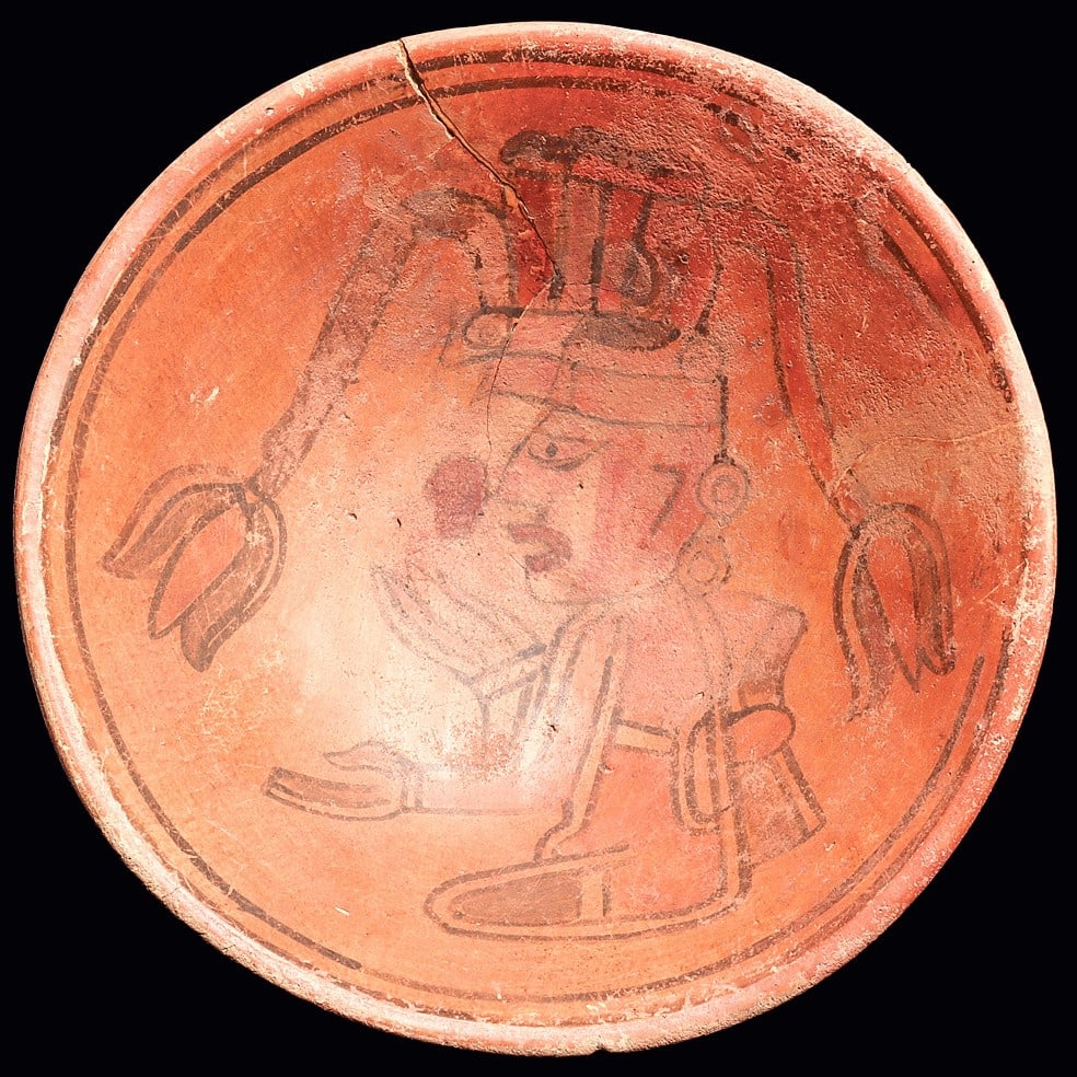 Maya Bowl with Seated Chief: Maya regions. Ca. 500 - 800 CE. Large pottery bowl, polychrome decorated on the interior with a seated chief wearing a headdress with two long stemmed floral elements, wearing double ear spools and ha