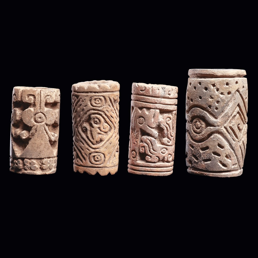 Ecuadorian Roller Seals (4) - Bird & Animal Motifs: Ecuador. Ca. 500 - 1000 CE. Group of four different large pottery roller seals, all having deeply carved designs with various geometric design elements, birds and animals. All are intact, exc. cond.