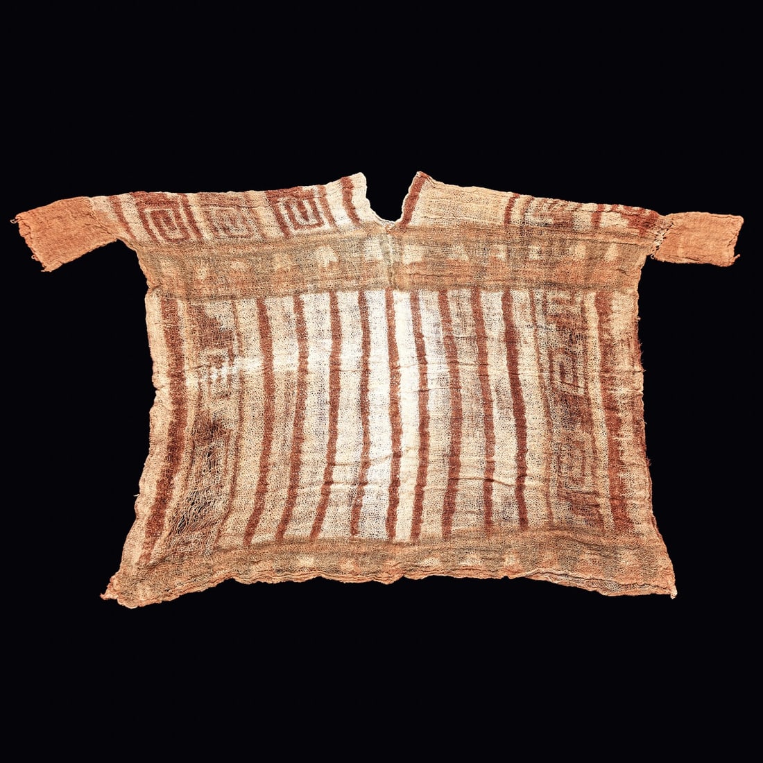 Rare Lambayeque Painted Gauze Shirt: Pre-Columbian, Lambayeque. Ca. 1000 - 1250 CE. A complete gauze shirt with sleeves and a v-neck. Overall painted striped and geometric designs in shades of blue and dark brown on a white ground. Some 