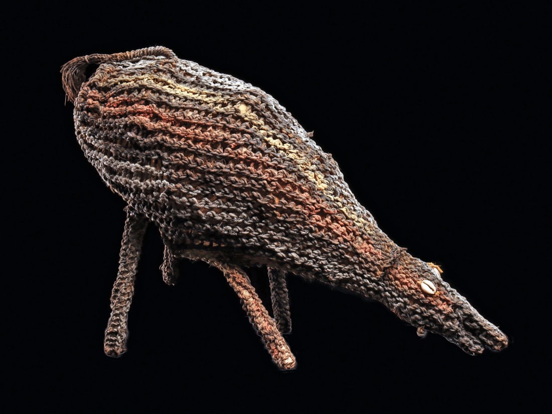 Dream Spirit Pig: Papua New Guinea.Woven fiber and cane internal structure in form of a wild pig standing on four slender legs with elongated head, curved small ears, cowry shell eyes, fringe tail, and painted with str