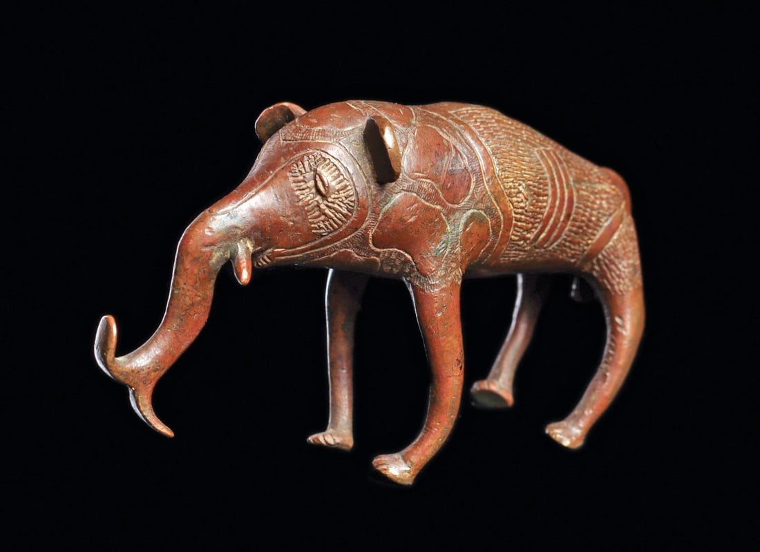 Fon Bronze Elephant: Republic of Benin (Dahomey).Fine copper alloy freestanding elephant with fine engraved surface detail, short tusks, trunk with flaring tip, and short tail. Red-brown patina with some white deposits