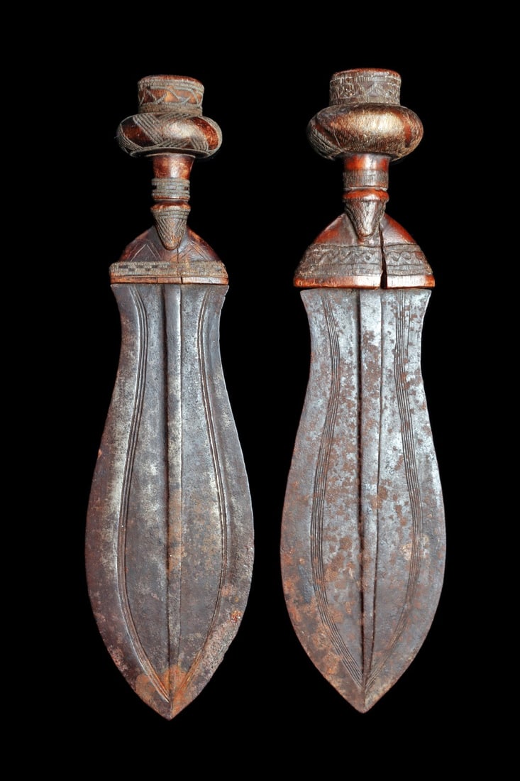 Kuba Ikul Knife Pair: Western Kasai, Democratic Republic of Congo. Ceremonial Kuba knives, known as the Peace knife, “ikul”, both with symmetrical leaf shaped iron blade and wood handle, meticulousy detailed