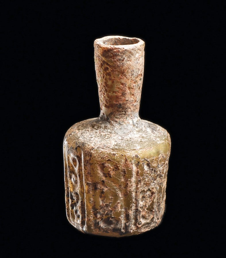 Byzantine Panel Molded Decorated Bottle: Eastern Mediterranean to Middle East. Ca. 4th - 7th century CE. Medium olive-yellow molded blown glass bottle having an eight panel body. Each panel is decorated in relief with a semiabstract bird and