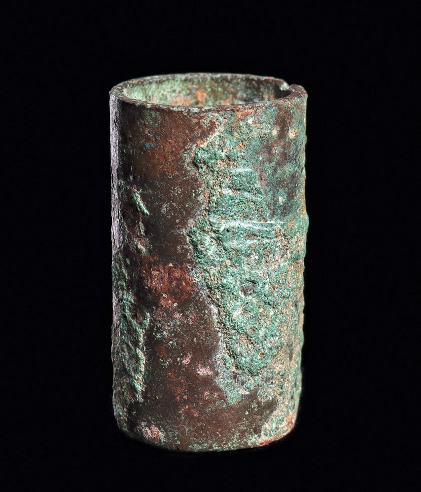 Bactrian Bronze Cylinder Cup: Ancient Near East. Ca. 1st millennium BCE. Undecorated cylindrical bronze cup, having a flat base and a small suspension hole on one side. Overall heavy blue-green encrusted surface patina. One tiny a